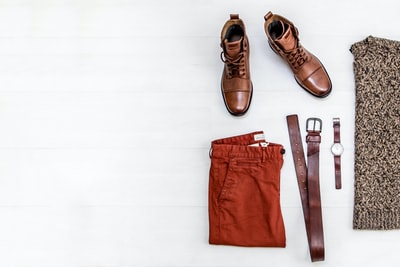一双棕色皮靴，红色短裤，棕色皮带，圆形金表，棕色上衣